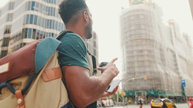 Genç turist modern binalarda cep telefonunda harita uygulaması kullanıyor