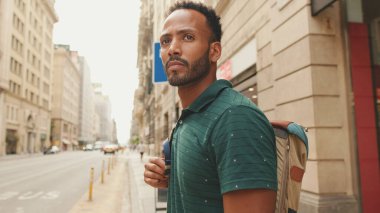 Genç bir turist eski şehrin meydanında yürüyor, manzaranın tadını çıkarıyor.