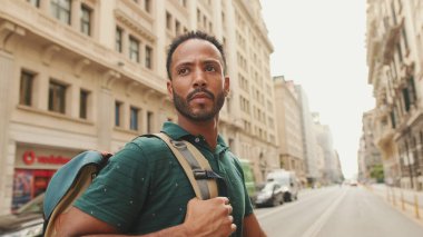 Genç bir turist eski şehrin meydanında yürüyor, manzaranın tadını çıkarıyor.