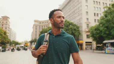 Genç bir turist eski şehrin meydanında yürüyor, manzaranın tadını çıkarıyor.