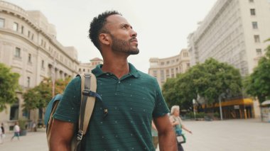 Genç bir turist eski şehrin meydanında yürüyor, manzaranın tadını çıkarıyor.