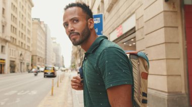 Genç bir turist eski şehrin meydanında yürüyor, manzaranın tadını çıkarıyor.