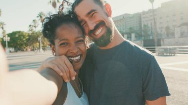 Close-up of interracial smiling couple in love taking selfie