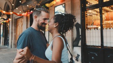 Happy interracial couple dancing outdoors