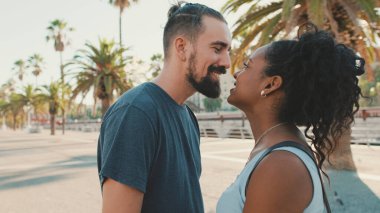 Close up, happy interracial family kisses outside