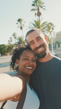 Close-up of interracial smiling couple in love taking selfie