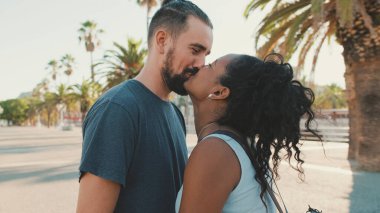 Close up, happy interracial family kisses outside
