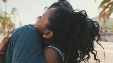 Happy interracial family hugging and kissing outside