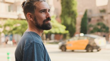 Young man with beard stands on crosswalk