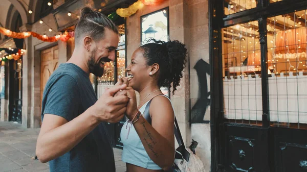 Happy interracial couple dancing outdoors