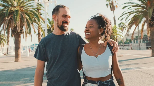 Happy Interracial Couple Walking Street Talking Smiling Man Hugs Woman — Stok fotoğraf