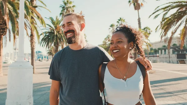 Happy Interracial Couple Walking Street Talking Smiling Man Hugs Woman — Stok fotoğraf