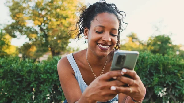 Laughing Young Mixed Race Woman Sitting Park Bench Using Cellphone — Foto de Stock