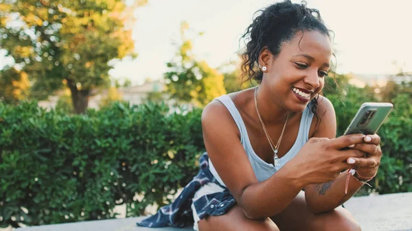 Laughing Young Mixed Race Woman Sitting Park Bench Using Cellphone — Fotografia de Stock