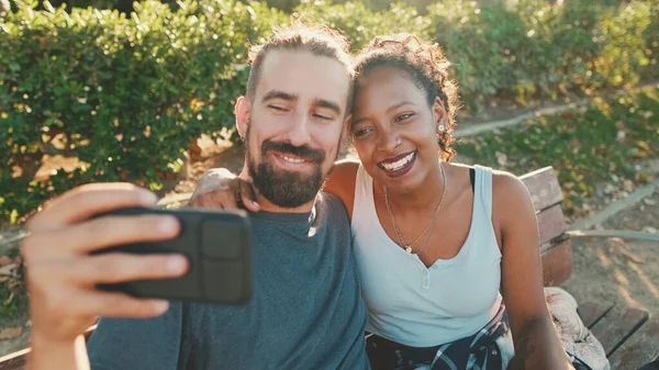Happy Smiling Interracial Couple Making Video Call Cellphone While Sitting — ストック写真