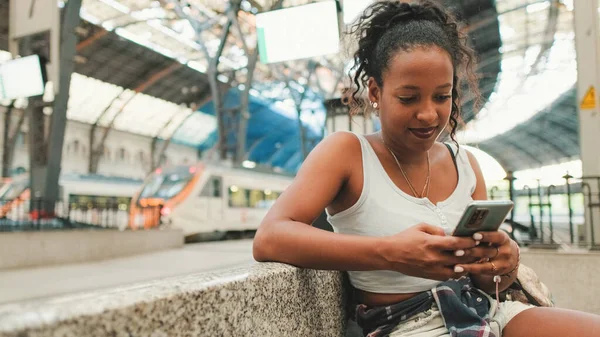 Young Mixed Race Woman Sitting Railway Station Using Cellphone —  Fotos de Stock