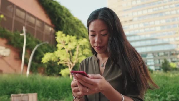 Jovem Usa Smartphone Enquanto Senta Prédios Modernos Fundo — Vídeo de Stock