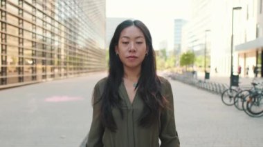 Genç bir kadın kollarını kavuşturup kameraya bakıyor.