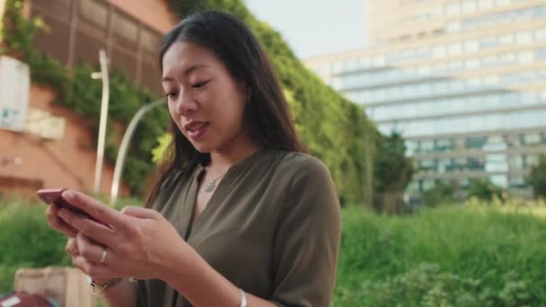 Jong Meisje Maakt Gebruik Van Smartphone Terwijl Zitten Moderne Gebouwen — Stockvideo
