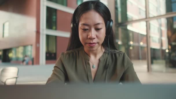 Молода Жінка Фрілансер Навушниках Працює Ноутбуці Піднімає Голову Посміхається Камеру — стокове відео