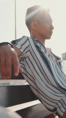 Genç turist, iskelede bankta oturuyor.