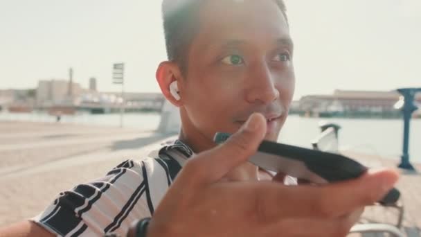 Yakından Genç Turist Rıhtımda Oturuyor Cep Telefonundan Sesli Mesaj Gönderiyor — Stok video