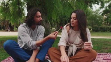 Kadın ve erkek piknikte battaniyenin üzerinde sağlıklı bir öğle yemeği yiyorlar.