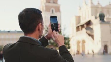 Adam eski şehrin meydanında fotoğraf çekiyor. Arka plan