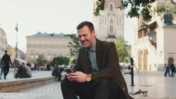 Мужчина Средних Лет Пользуется Мобильным Телефоном Фоне Старого Города — стоковое видео