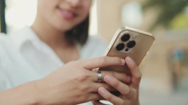 Cep telefonu kullanan genç bir kadının ellerini yakın plan çek.