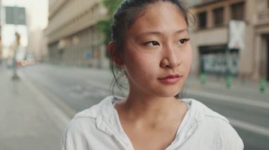 Kameraya bakıp gülümseyen genç bir kadının yakın çekimi.