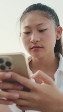 Kapatın, genç bayan limanda otururken cep telefonu kullanıyor.