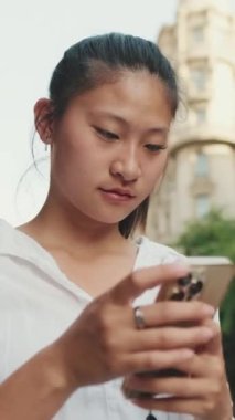 Yol kenarında dururken cep telefonu kullanan genç bir kadın var ya?