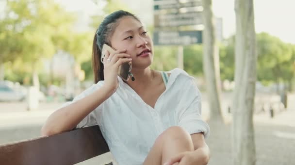 Jonge Vrouw Zittend Een Bankje Praten Mobiele Telefoon — Stockvideo