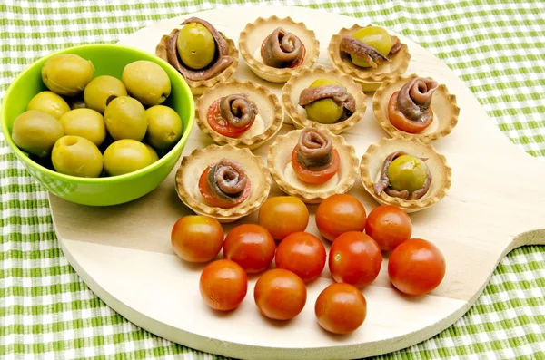 Snacks de aceitunas, anchoas y tomates — Foto de Stock