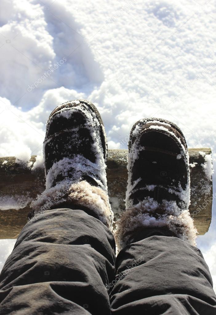 Feet in boots in the snow.