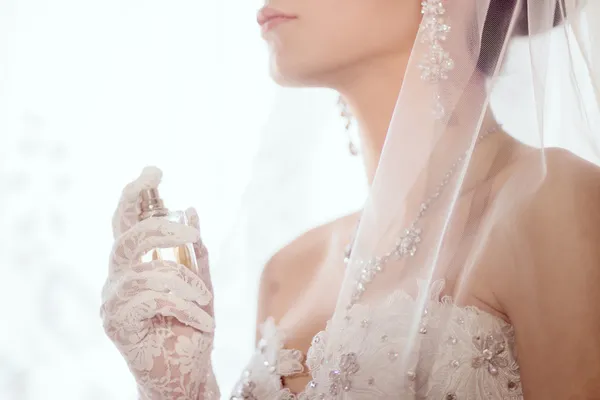 Nahaufnahme einer jungen Frau mit Parfüm im Hochzeitskleid — Stockfoto