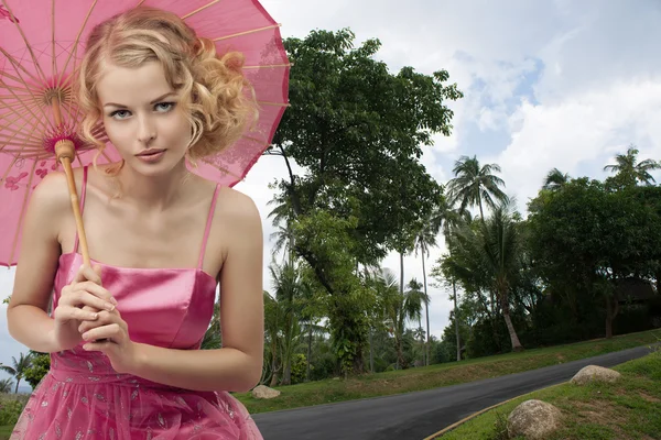 Mooie blonde vrouw met parasol in het Thaise park — Stockfoto