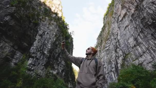 Filming on smart phone camera. Tourist shots mountains during high hill hiking. — Stock Video