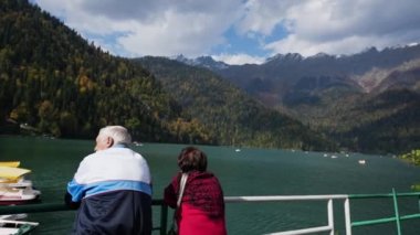 Yaşlı adam ve kadın turistler dağ gölü doğal tatil beldesini geziyorlar..