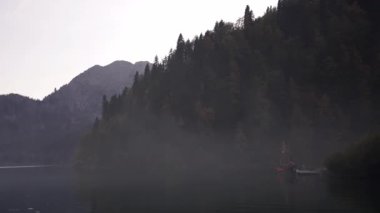 Göl yüzeyindeki sis. Dağ suyunun sonbahar doğası. İnanılmaz bir tatil köyü.