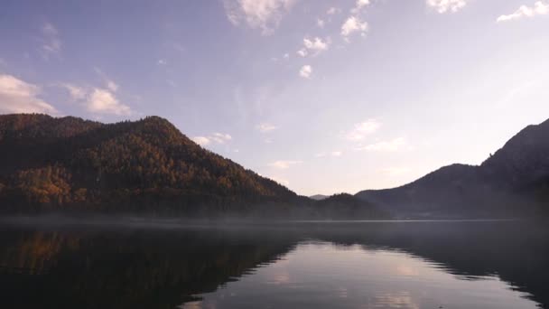 Мовчазна вода осіннього гірського озера з човнами повільно плаває на фоні . — стокове відео