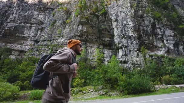 Séta a hegyi úton. Férfi turista kirándulás hátizsákkal. — Stock videók