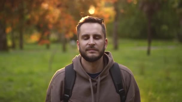 Portrait face of looking at camera bearded traveler with backpack on hiking trip — Stock Video