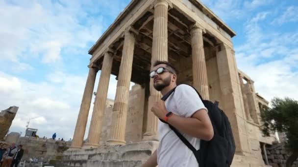 Άνδρας τουρίστας περνά το χρόνο του περπατώντας ανάμεσα σε πυλώνες της αρχαίας Ακρόπολης στην Αθήνα — Αρχείο Βίντεο