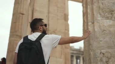 Atina 'nın içindeki turist adam Akropolis antik harabe tapınağın sütunlarına dokunuyor
