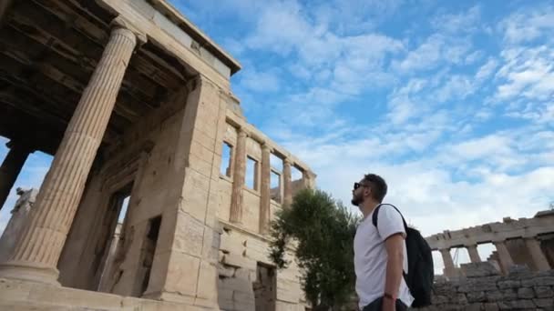 Podróżnik przygląda się klasycznej greckiej architekturze na wzgórzu Akropolu. — Wideo stockowe