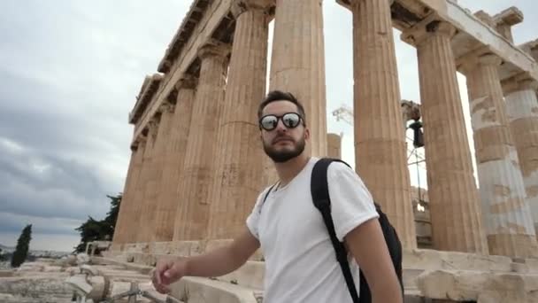 Turista v brýlích, jak se prochází a mluví o Akropolis Hill v Aténách. — Stock video