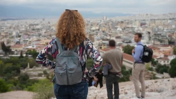 Vrouwelijke toerist op Acropolis heuvel kijkend naar Grieks Athene. Historisch toerisme. — Stockvideo