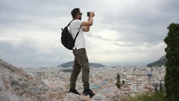 Τουριστικός άνδρας φωτογράφος φωτογραφίζει, φωτογραφίζει την Αθήνα από το λόφο της Ακρόπολης. — Αρχείο Βίντεο